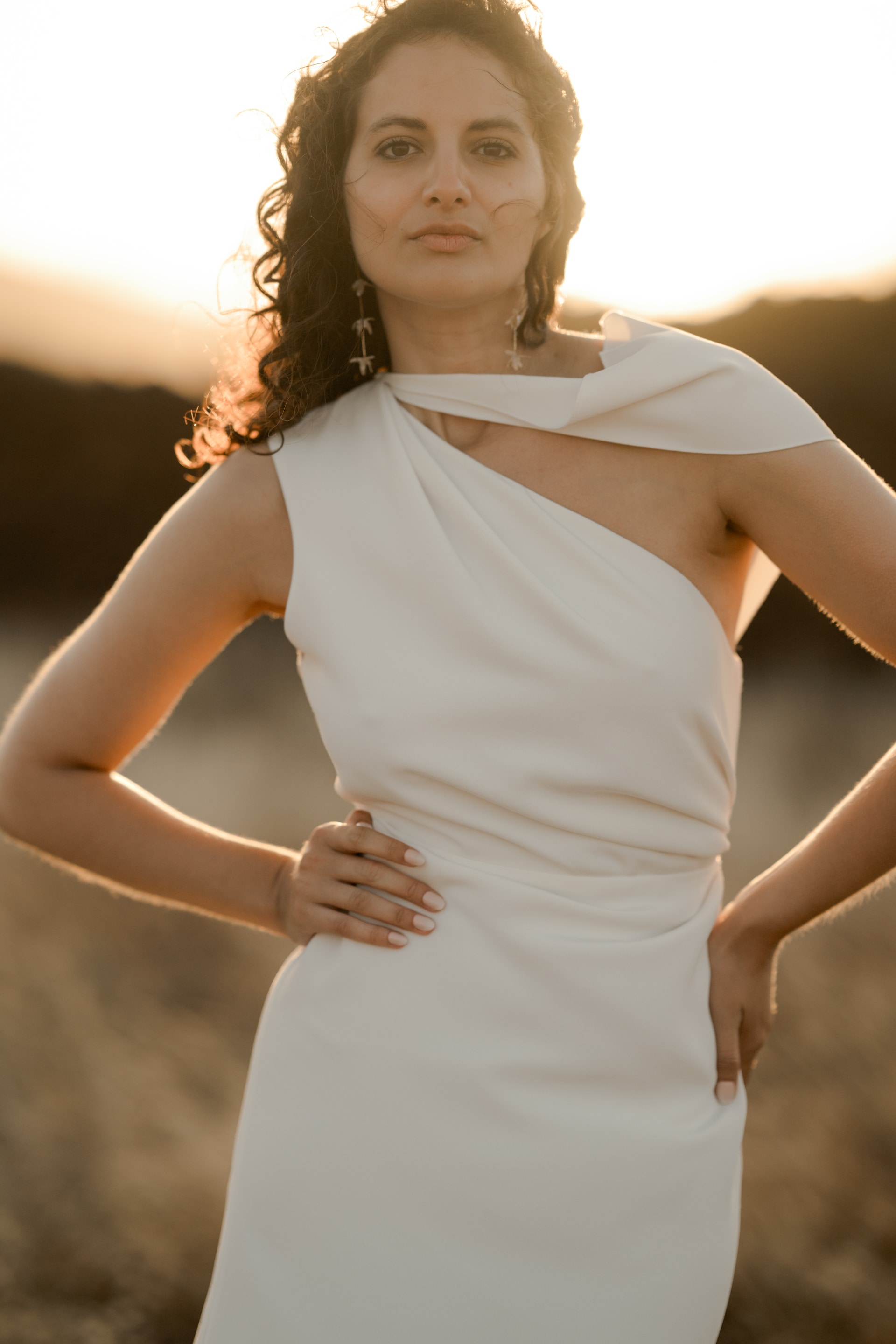 ONDINE est une robe de mariée chic en crêpe de soie. Son décolleté asymétrique en fait une robe de mariée élégante. C’est une robe de mariée drapée féminine pour un mariage cool et chic. Bijoux @anthemis.paris