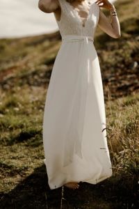 INBORN Robe de mariée bohème chic fluide en crêpe et fine broderie anglaise. Taille soulignée d’une ceinture.