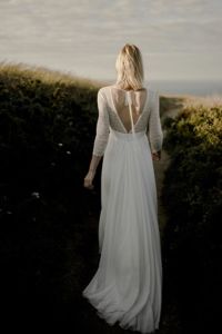 IPHIGENIE Une robe de mariée bohème chic en dentelle de Calais. Manches ¾ et grand V dos, avec ou sans ruban. Jupe vaporeuse en crêpe georgette de soie et plissé.
