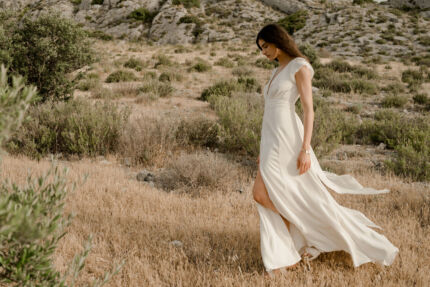 LA ROBE AIGUE MARINE est une robe de mariée moderne et minimaliste en crêpe de soie ultra fluide et légère agrémentée de petites manches volantes et d’une ceinture drapée en mousseline de soie. Elle est sensuelle et légère pour une mariée authentique. LA ROBE AIGUE MARINE