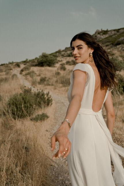 LA ROBE AIGUE MARINE est une robe de mariée moderne et minimaliste en crêpe de soie ultra fluide et légère agrémentée de petites manches volantes et d’une ceinture drapée en mousseline de soie. Elle est sensuelle et légère pour une mariée authentique. LA ROBE AIGUE MARINE