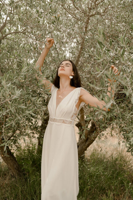 LA ROBE LIGHT est une robe de mariée moderne et chic en crêpe écoresponsable et broderie de coquelicots française. Son décolleté plongeant et les jeux de transparence en feront une mariée sensuelle. LA ROBE LIGHT