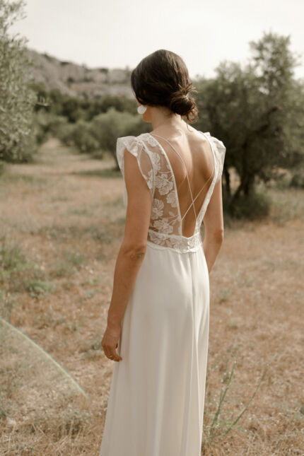 LA ROBE LIGHT est une robe de mariée moderne et chic en crêpe écoresponsable et broderie de coquelicots française. Son décolleté plongeant et les jeux de transparence en feront une mariée sensuelle. LA ROBE LIGHT