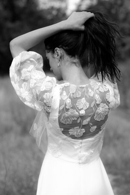 LA ROBE LONG LIVED est une robe de mariée moderne et minimaliste toute en crêpe écoresponsable ; une grande simplicité pour une mariée avec une forte personnalité. La blouse KISS en broderie coquelicots, made in France, lui apportera une touche espiègle et poétique pour une mariée bohème chic. LA ROBE LONG LIVED