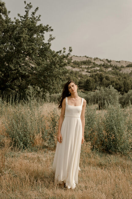 LA ROBE LONG LIVED est une robe de mariée moderne et minimaliste toute en crêpe écoresponsable ; une grande simplicité pour une mariée avec une forte personnalité. La blouse KISS en broderie coquelicots, made in France, lui apportera une touche espiègle et poétique pour une mariée bohème chic. LA ROBE LONG LIVED