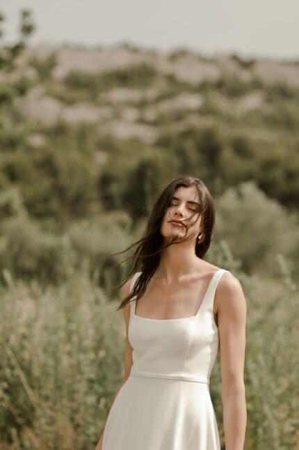 LA ROBE LONG LIVED est une robe de mariée moderne et minimaliste toute en crêpe écoresponsable ; une grande simplicité pour une mariée avec une forte personnalité. La blouse KISS en broderie coquelicots, made in France, lui apportera une touche espiègle et poétique pour une mariée bohème chic. LA ROBE LONG LIVED