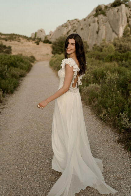 LA ROBE LUCKY LOVE est une robe de mariée en crêpe écoresponsable et mousseline de soie avec un buste tout en guipure et les épaules habillées de volants, pour une mariée débordante d’énergie et de gaîté de vivre. LA ROBE LUCKY LOVE