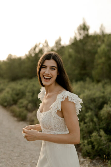 LA ROBE LUCKY LOVE est une robe de mariée en crêpe écoresponsable et mousseline de soie avec un buste tout en guipure et les épaules habillées de volants, pour une mariée débordante d’énergie et de gaîté de vivre. LA ROBE LUCKY LOVE