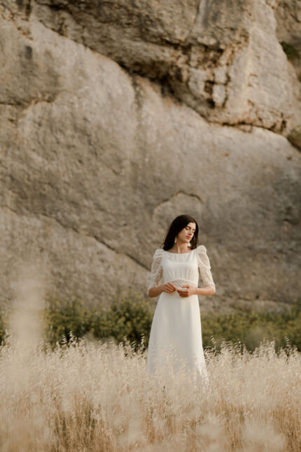 LA ROBE LOOKER est une robe de mariée moderne très chic. En crêpe fluide et guipure écoresponsable, ses manches rehaussées, sa taille transparente et son grand décolleté dans le dos apportent force et originalité pour une mariée affirmée. Bijoux LA ROBE LOOKER