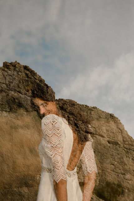 LA ROBE LOOKER est une robe de mariée moderne très chic. En crêpe fluide et guipure écoresponsable, ses manches rehaussées, sa taille transparente et son grand décolleté dans le dos apportent force et originalité pour une mariée affirmée. Bijoux LA ROBE LOOKER