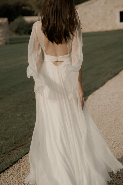 NAÏADE est une robe de mariée créateur. Toute en mousseline de soie plissée sur le buste, avec de longues manches vaporeuses pour celles qui cherchent une note couture.