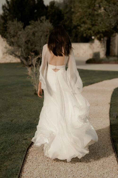 NAÏADE est une robe de mariée créateur. Toute en mousseline de soie plissée sur le buste, avec de longues manches vaporeuses pour celles qui cherchent une note couture.