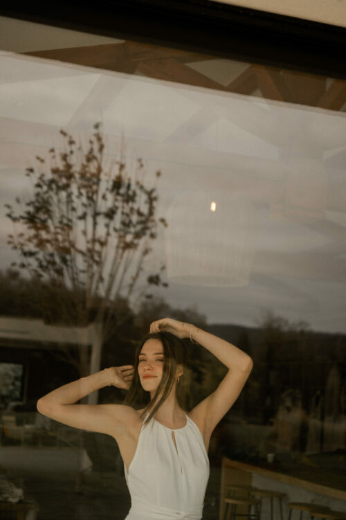 NAÏS est une robe de mariée moderne. On aimera son buste plissé et son dos audacieux en broderie de grandes fleurs.