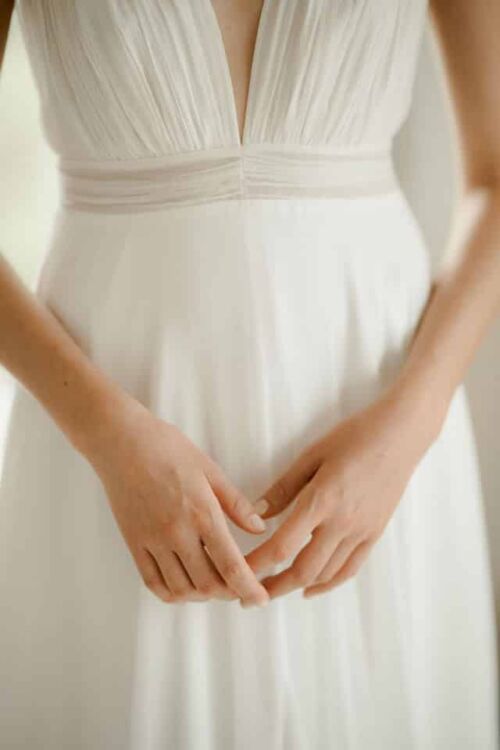 NOBILITA est une robe de mariée moderne, toute en mousseline de soie, plissée sur le buste. C'est une robe de mariée sans manches qui étonnera par sa très grande légèreté.