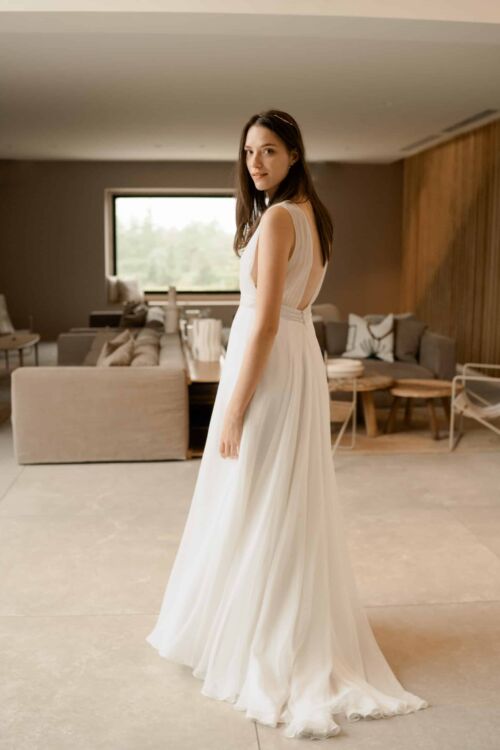 NOBILITA est une robe de mariée moderne, toute en mousseline de soie, plissée sur le buste. C'est une robe de mariée sans manches qui étonnera par sa très grande légèreté.