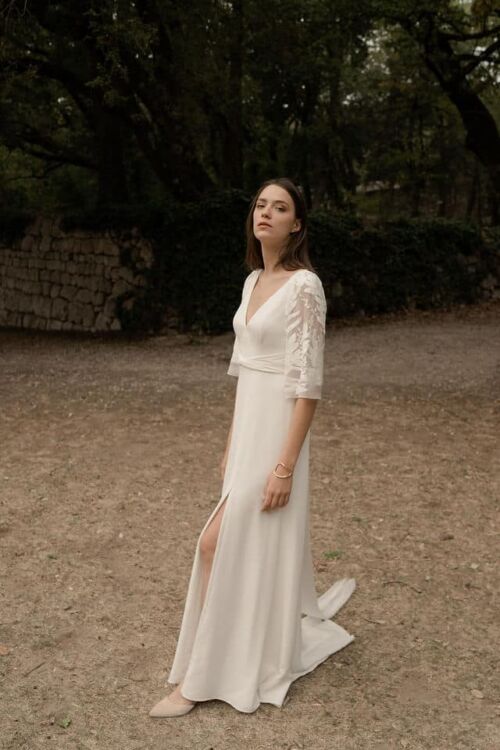 OLYMPE est une robe de mariée en crêpe de soie qui séduira par le style vintage que donne cette magnifique mousseline brodée de feuilles sur les manches et le dos.