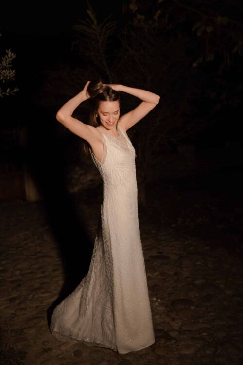 OPERA est une sur-robe de mariée entièrement perlée pour un mariage glamour, portée sur une robe en soie à fines bretelles .