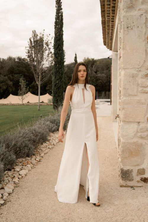 NUNCIA est une robe de mariée moderne et chic. L'élégance du col charmera celles qui ne veulent pas de décolleté.