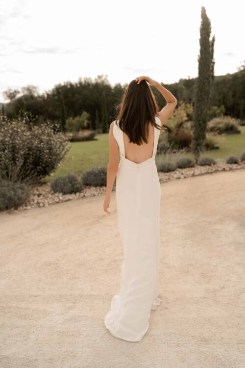 NUNCIA est une robe de mariée moderne et chic. L'élégance du col charmera celles qui ne veulent pas de décolleté.