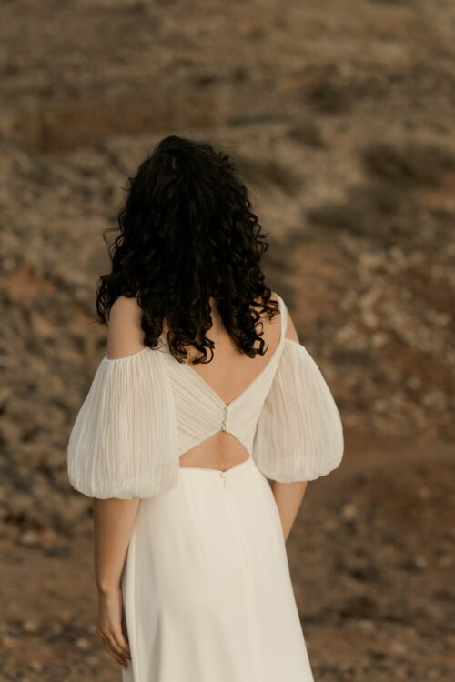 PODER PARA TI est un ensemble de mariée moderne et sexy, composé d'un bustier de mariée drapé de mousseline de soie plissée et d'une jupe de mariée fluide en crêpe de soie. Les manches bouffantes de cet ensemble de mariage sont amovibles.