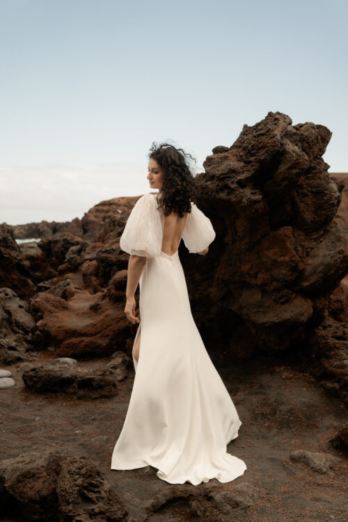 PODEROSA est une robe de mariée moderne. Ses manches bouffantes et sa taille transparente sont en mousseline plissée. Bijoux @anthemis.paris