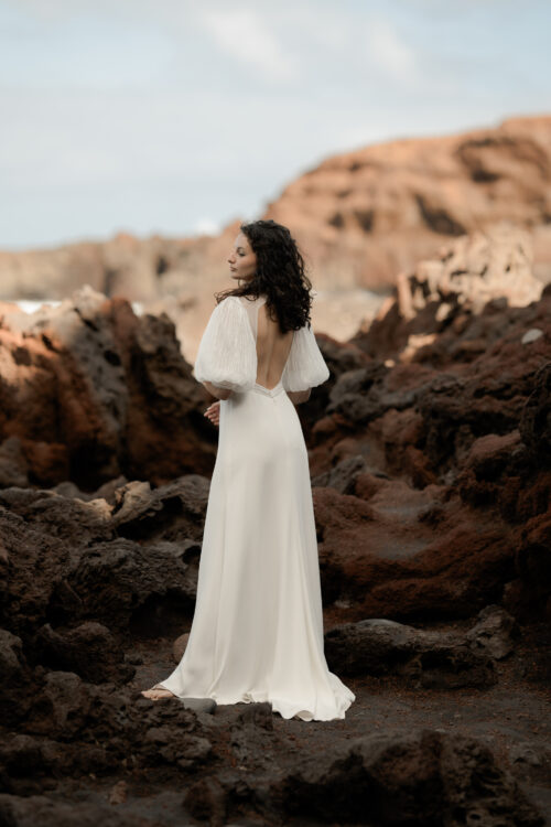 PODEROSA est une robe de mariée moderne. Ses manches bouffantes et sa taille transparente sont en mousseline plissée. Bijoux @anthemis.paris