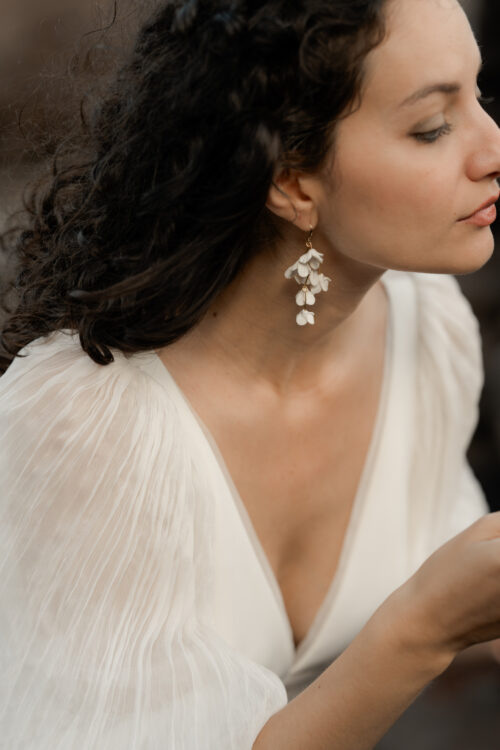 PODEROSA est une robe de mariée moderne. Ses manches bouffantes et sa taille transparente sont en mousseline plissée. Bijoux @anthemis.paris