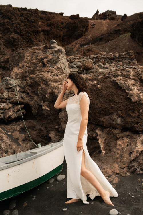 Passion est une robe de mariée minimaliste en crêpe eco-friendly avec de fines bretelles et une fente sur le côté. Son dos-nu original en fait une robe de mariée moderne. Cette robe de mariée simple pourra être portée avec PROSPER notre petit top de mariage transparent en broderie de perles ou en broderie de plumes. Bijoux @anthemis.paris