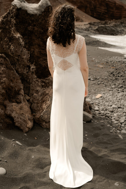 Passion est une robe de mariée minimaliste en crêpe eco-friendly avec de fines bretelles et une fente sur le côté. Son dos-nu original en fait une robe de mariée moderne. Cette robe de mariée simple pourra être portée avec PROSPER notre petit top de mariage transparent en broderie de perles ou en broderie de plumes. Bijoux @anthemis.paris