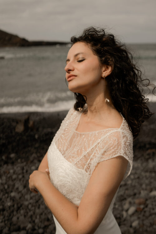 Passion est une robe de mariée minimaliste en crêpe eco-friendly avec de fines bretelles et une fente sur le côté. Son dos-nu original en fait une robe de mariée moderne. Cette robe de mariée simple pourra être portée avec PROSPER notre petit top de mariage transparent en broderie de perles ou en broderie de plumes. Bijoux @anthemis.paris