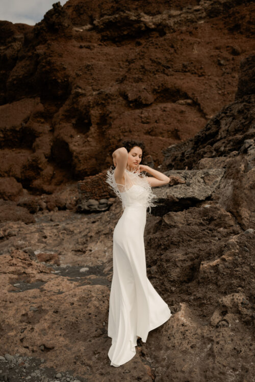 Passion est une robe de mariée minimaliste en crêpe eco-friendly avec de fines bretelles et une fente sur le côté. Son dos-nu original en fait une robe de mariée moderne. Cette robe de mariée simple pourra être portée avec PROSPER notre petit top de mariage transparent en broderie de perles ou en broderie de plumes. Bijoux @anthemis.paris