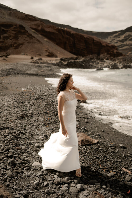 Passion est une robe de mariée minimaliste en crêpe eco-friendly avec de fines bretelles et une fente sur le côté. Son dos-nu original en fait une robe de mariée moderne. Cette robe de mariée simple pourra être portée avec PROSPER notre petit top de mariage transparent en broderie de perles ou en broderie de plumes. Bijoux @anthemis.paris