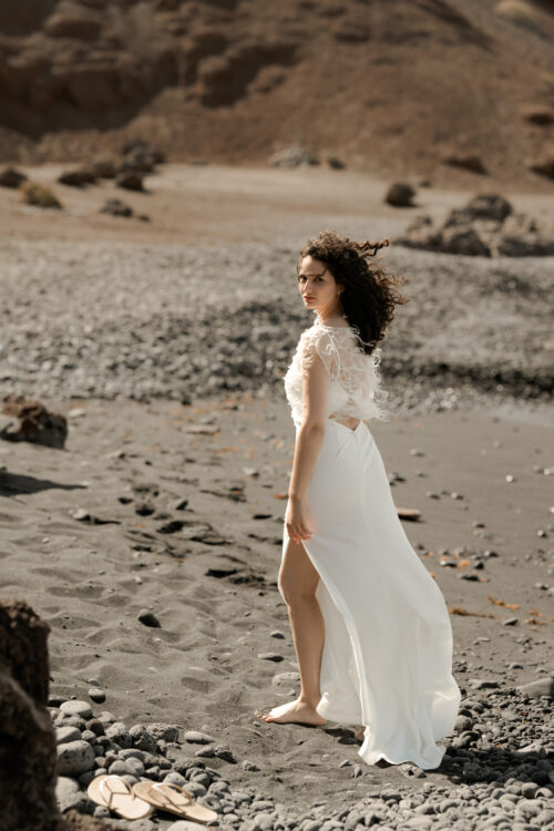 Passion est une robe de mariée minimaliste en crêpe eco-friendly avec de fines bretelles et une fente sur le côté. Son dos-nu original en fait une robe de mariée moderne. Cette robe de mariée simple pourra être portée avec PROSPER notre petit top de mariage transparent en broderie de perles ou en broderie de plumes. Bijoux @anthemis.paris