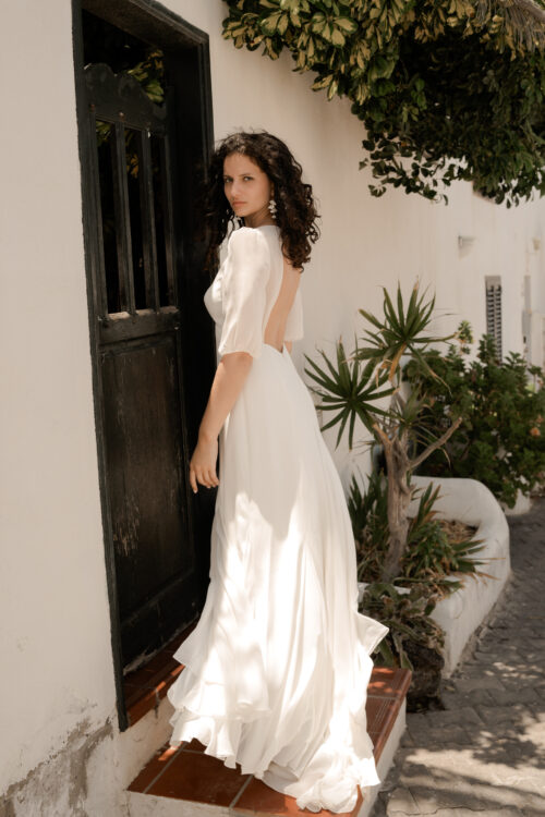 PAIX est une robe de mariée épurée en crêpe de soie et mousseline de soie. Son élégance conviendra parfaitement pour mariage cool et chic. C’est une robe de mariée fluide et légère. Elle se compose d’une jupe évasée par des incrustations de mousseline de soie et d’un dos nu de mariée délicat, pour une robe de mariée sobre et élégante. Bijoux @anthemis.paris