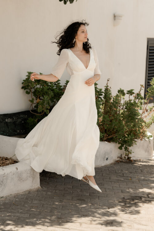 PAIX est une robe de mariée épurée en crêpe de soie et mousseline de soie. Son élégance conviendra parfaitement pour mariage cool et chic. C’est une robe de mariée fluide et légère. Elle se compose d’une jupe évasée par des incrustations de mousseline de soie et d’un dos nu de mariée délicat, pour une robe de mariée sobre et élégante. Bijoux @anthemis.paris