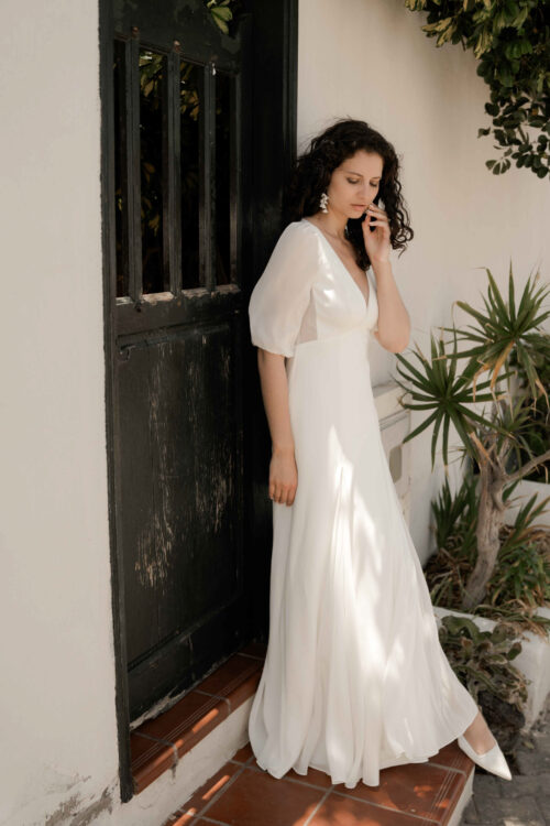 PAIX est une robe de mariée épurée en crêpe de soie et mousseline de soie. Son élégance conviendra parfaitement pour mariage cool et chic. C’est une robe de mariée fluide et légère. Elle se compose d’une jupe évasée par des incrustations de mousseline de soie et d’un dos nu de mariée délicat, pour une robe de mariée sobre et élégante. Bijoux @anthemis.paris