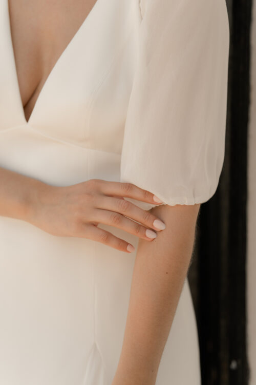 PAIX est une robe de mariée épurée en crêpe de soie et mousseline de soie. Son élégance conviendra parfaitement pour mariage cool et chic. C’est une robe de mariée fluide et légère. Elle se compose d’une jupe évasée par des incrustations de mousseline de soie et d’un dos nu de mariée délicat, pour une robe de mariée sobre et élégante. Bijoux @anthemis.paris
