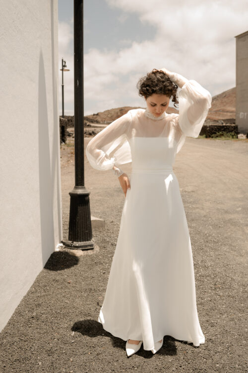 PURITY est une robe de mariée bustier en crêpe eco-friendly avec la taille soulignée d’une ceinture drapée. C’est une robe de mariée minimaliste pour un mariage chic. PABLO est une blouse de mariée en mousseline de soie avec les poignets et le col en fine broderie qui apportera une note très chic à cette tenue de mariée simple.