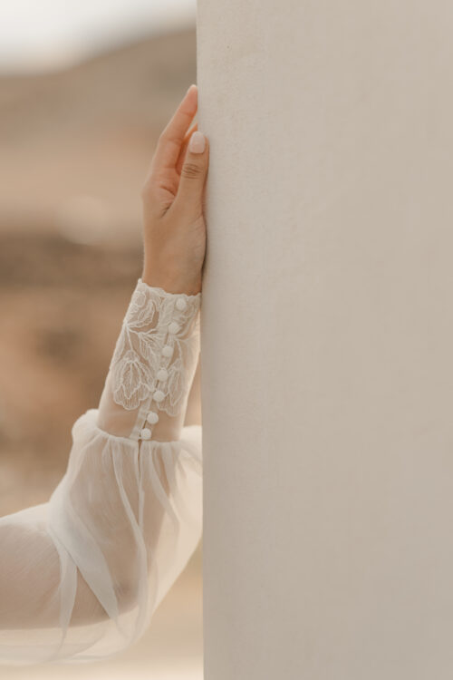 PURITY est une robe de mariée bustier en crêpe eco-friendly avec la taille soulignée d’une ceinture drapée. C’est une robe de mariée minimaliste pour un mariage chic. PABLO est une blouse de mariée en mousseline de soie avec les poignets et le col en fine broderie qui apportera une note très chic à cette tenue de mariée simple.
