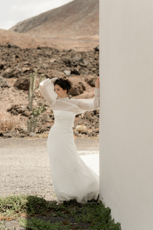 PURITY est une robe de mariée bustier en crêpe eco-friendly avec la taille soulignée d’une ceinture drapée. C’est une robe de mariée minimaliste pour un mariage chic. PABLO est une blouse de mariée en mousseline de soie avec les poignets et le col en fine broderie qui apportera une note très chic à cette tenue de mariée simple.