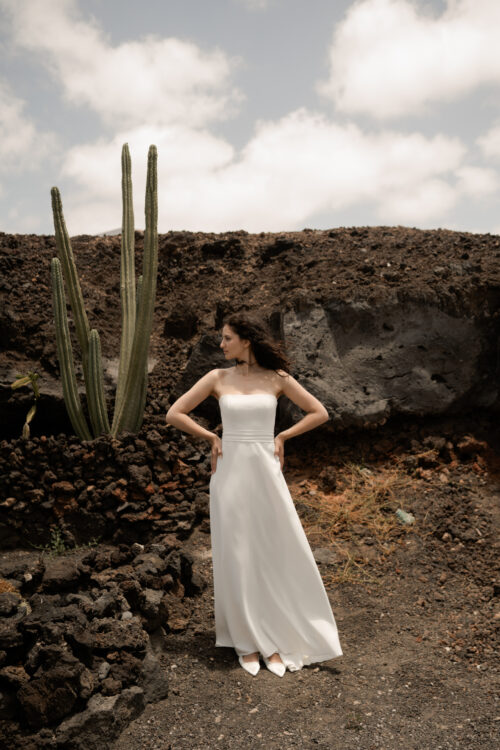 PURITY est une robe de mariée bustier en crêpe eco-friendly avec la taille soulignée d’une ceinture drapée. C’est une robe de mariée minimaliste pour un mariage chic. PABLO est une blouse de mariée en mousseline de soie avec les poignets et le col en fine broderie qui apportera une note très chic à cette tenue de mariée simple.