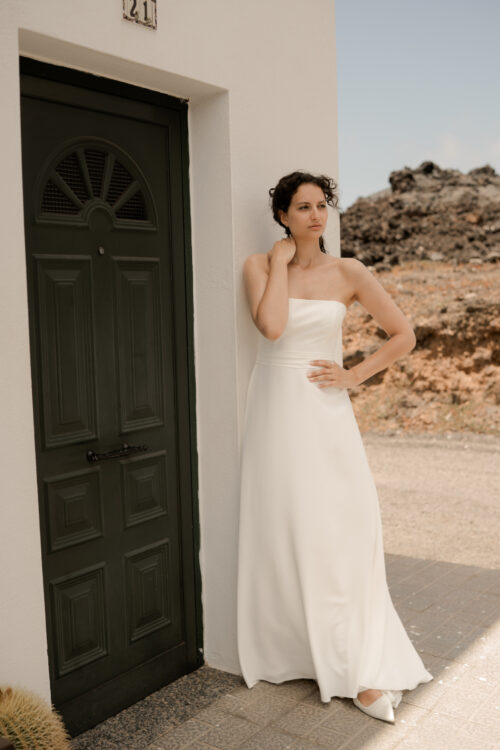 PURITY est une robe de mariée bustier en crêpe eco-friendly avec la taille soulignée d’une ceinture drapée. C’est une robe de mariée minimaliste pour un mariage chic. PABLO est une blouse de mariée en mousseline de soie avec les poignets et le col en fine broderie qui apportera une note très chic à cette tenue de mariée simple.