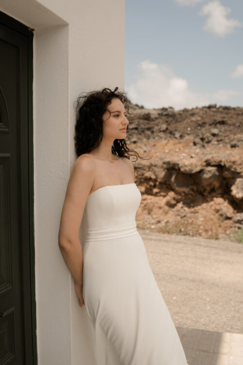 PURITY est une robe de mariée bustier en crêpe eco-friendly avec la taille soulignée d’une ceinture drapée. C’est une robe de mariée minimaliste pour un mariage chic. PABLO est une blouse de mariée en mousseline de soie avec les poignets et le col en fine broderie qui apportera une note très chic à cette tenue de mariée simple.