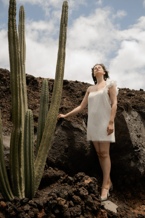 PEARLS est une robe de mariée courte en crêpe et broderie de perles, ornée de grosses fleurs sur l’épaule. Elle sera parfaite comme tenue de mariée civile ou pour un mariage simple. Bijoux @anthemis.paris Chaussures @flordeasoka_paris