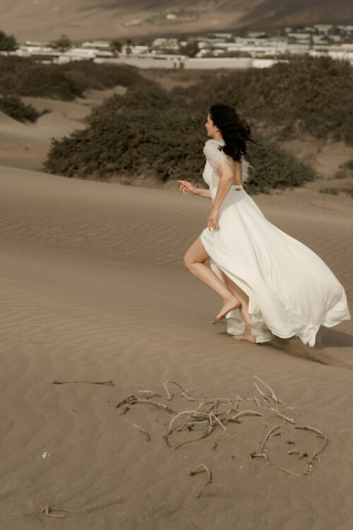 PROMISE est une robe de mariée moderne en crêpe eco-friendly avec des manches courtes en broderie de plumes. C’est une robe de mariée chic avec une jupe de mariée ample et fendue. Cette robe de mariée dos nu sera parfaite pour un mariage cool et chic. En réalisant votre robe de mariée sur mesure, vous pourrez opter pour les manches de votre choix. Bijoux @anthemis.paris