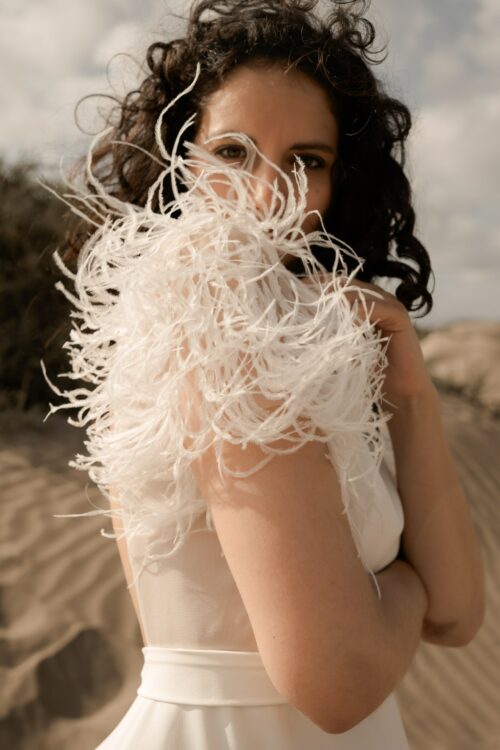 PROMISE est une robe de mariée moderne en crêpe eco-friendly avec des manches courtes en broderie de plumes. C’est une robe de mariée chic avec une jupe de mariée ample et fendue. Cette robe de mariée dos nu sera parfaite pour un mariage cool et chic. En réalisant votre robe de mariée sur mesure, vous pourrez opter pour les manches de votre choix. Bijoux @anthemis.paris