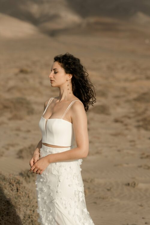 L’ensemble de mariée Pistil et Pollen se compose d’une jupe de mariée en tulle brodé de fleurs et d’un bustier de mariée en crêpe. C’est une tenue de mariée moderne pour un mariage bohème, cool et chic. Bijoux @anthemis.paris