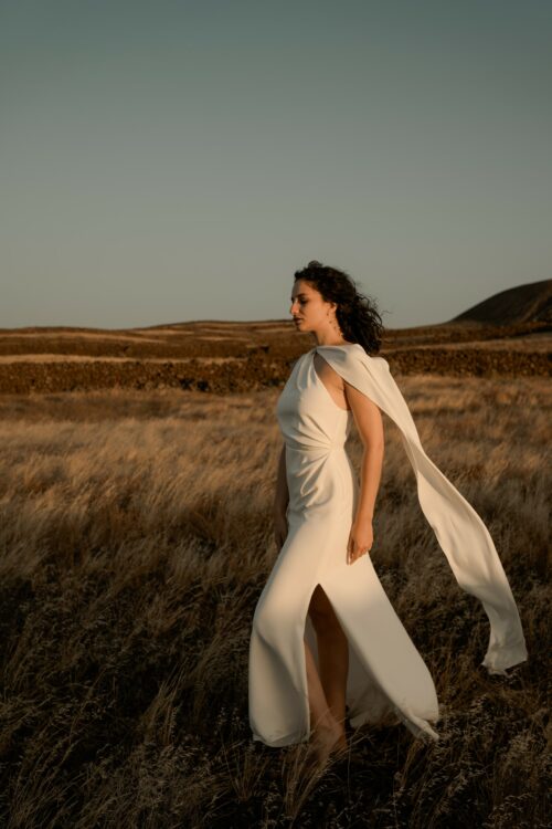 ONDINE est une robe de mariée chic en crêpe de soie. Son décolleté asymétrique en fait une robe de mariée élégante. C’est une robe de mariée drapée féminine pour un mariage cool et chic. Bijoux @anthemis.paris