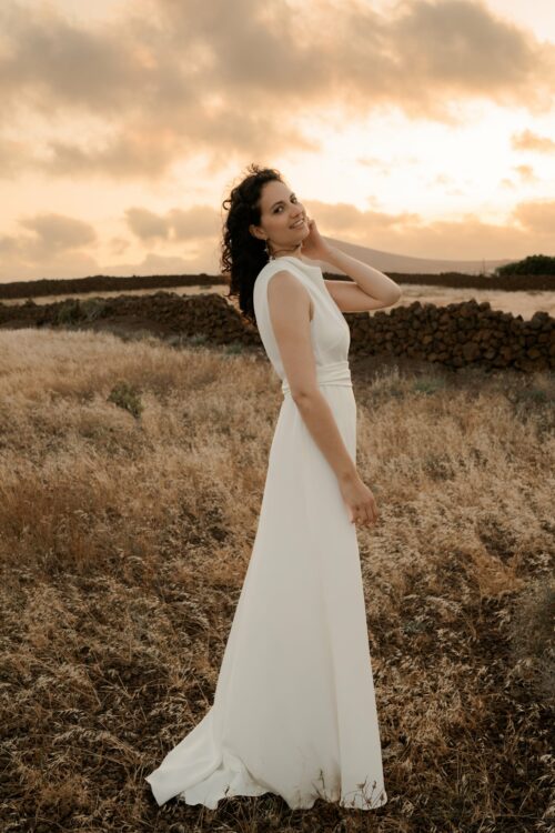PERFECTUM est une robe de mariée chic. Le col et la ceinture sont en crêpe de soie drapé avec délicatesse. Cette robe de mariée minimaliste conviendra parfaitement pour un mariage cool et chic. Bijoux @anthemis.paris.