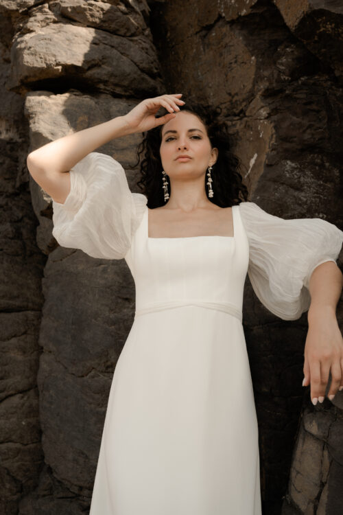 POWERFUL est une robe de mariée chic en crêpe de soie avec des manches bouffantes en mousseline de soie plissée. Son décolleté carré conviendra parfaitement aux filles qui cherchent une robe de mariée pour forte poitrine. Bijoux @anthemis.paris